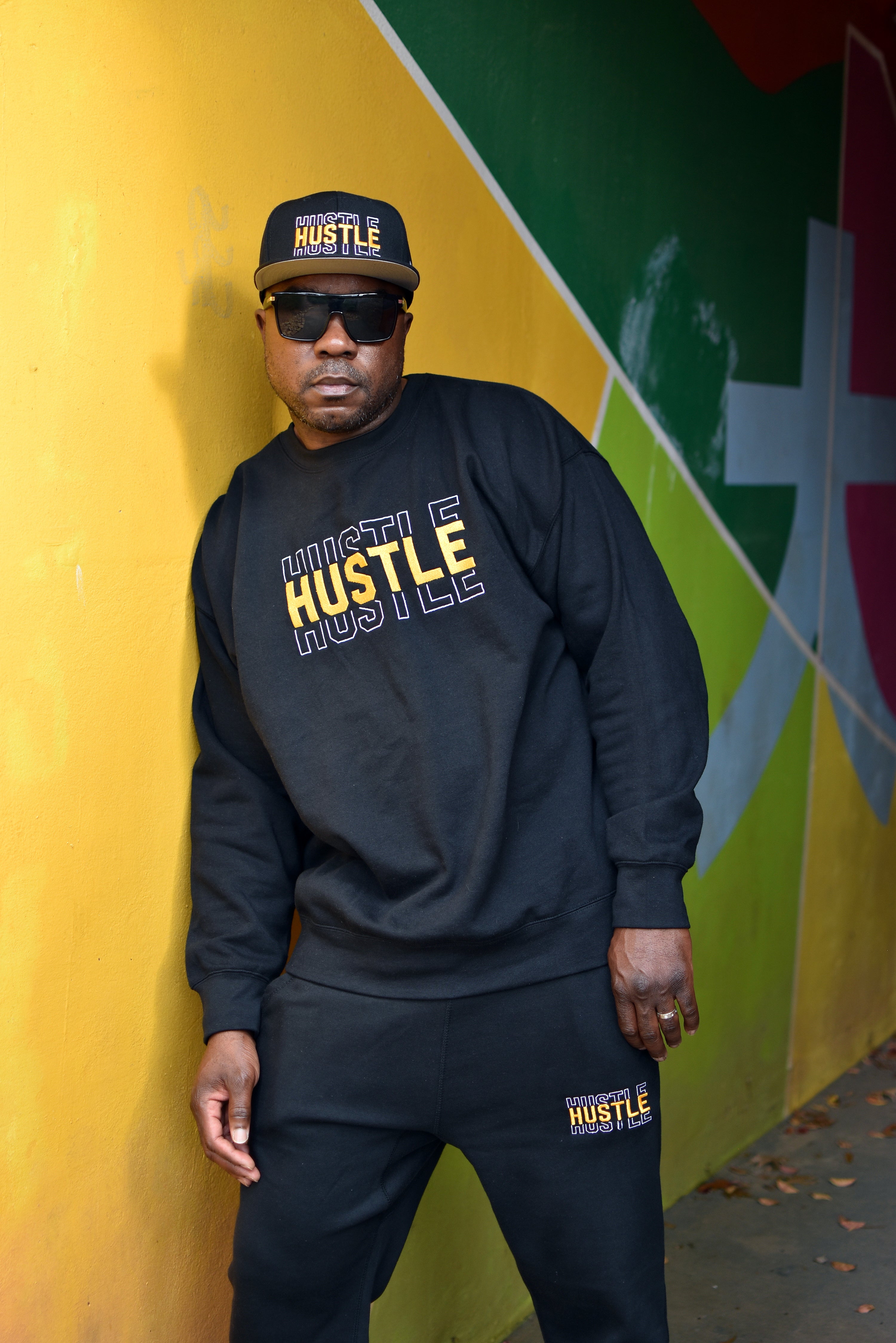 85 North CEO John Petersen wearing the Hustle Embroidered hat, sweatshirt and joggers.